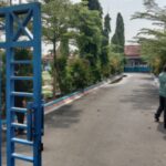 Para petugas keamanan berjaga di depan pintu pagar SMP Negeri 3 Comal, menghindar saat wartawan mengambil gambar